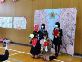 桜並み木の写真の映えスポットで写真を撮る卒業生の画像2