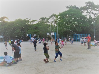 校庭で水鉄砲を使って遊ぶ参加者たちの写真