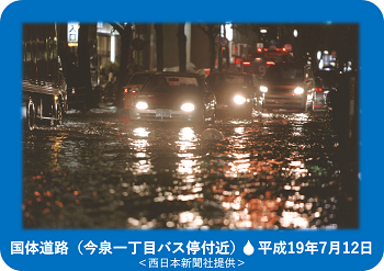 これは平成19年7月12日の豪雨の際の国体道路，今泉１丁目バス停付近の状況写真です，この写真は西日本新聞社から提供を受けたものです。
