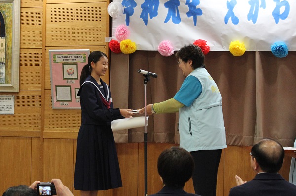 ロゴマーク最優秀賞を受賞される中学生の大岩さんと表彰状を渡す湯口公民館長
