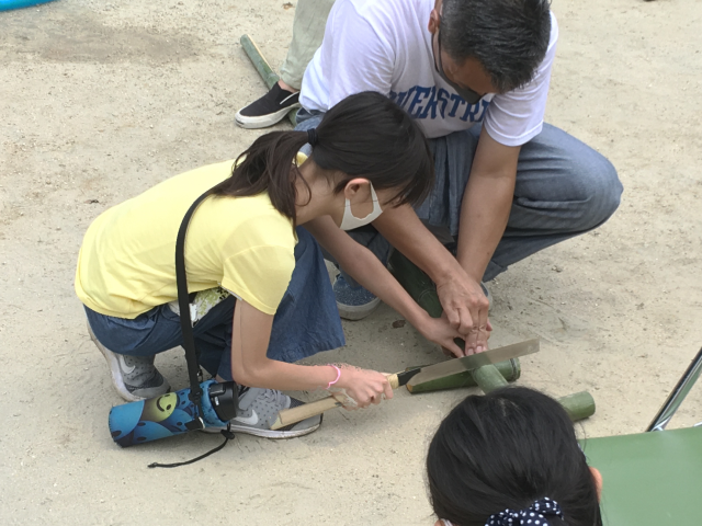 竹の切り方を教えている写真
