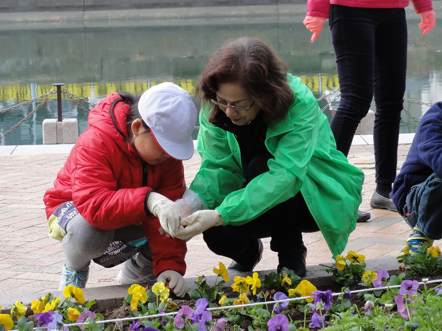 松尾英子さんと子供が花壇の手入れをしている様子