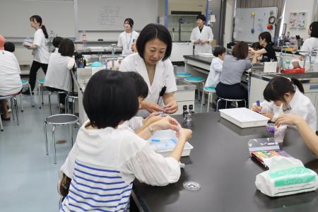 講師の新井先生が、各テーブルを回りながら参加者の様子を見ている様子