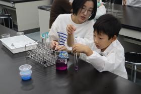 参加者の子どもが色素溶液を試験管へ移し替えている様子