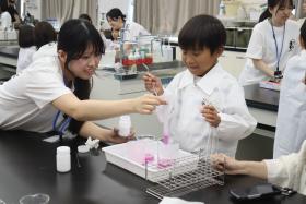 大学生が参加者の子どもをサポートしながら、実験を進めている様子
