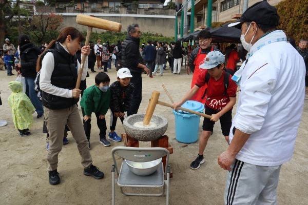 声援を受けながら、子どもと一緒に餅をつく区長