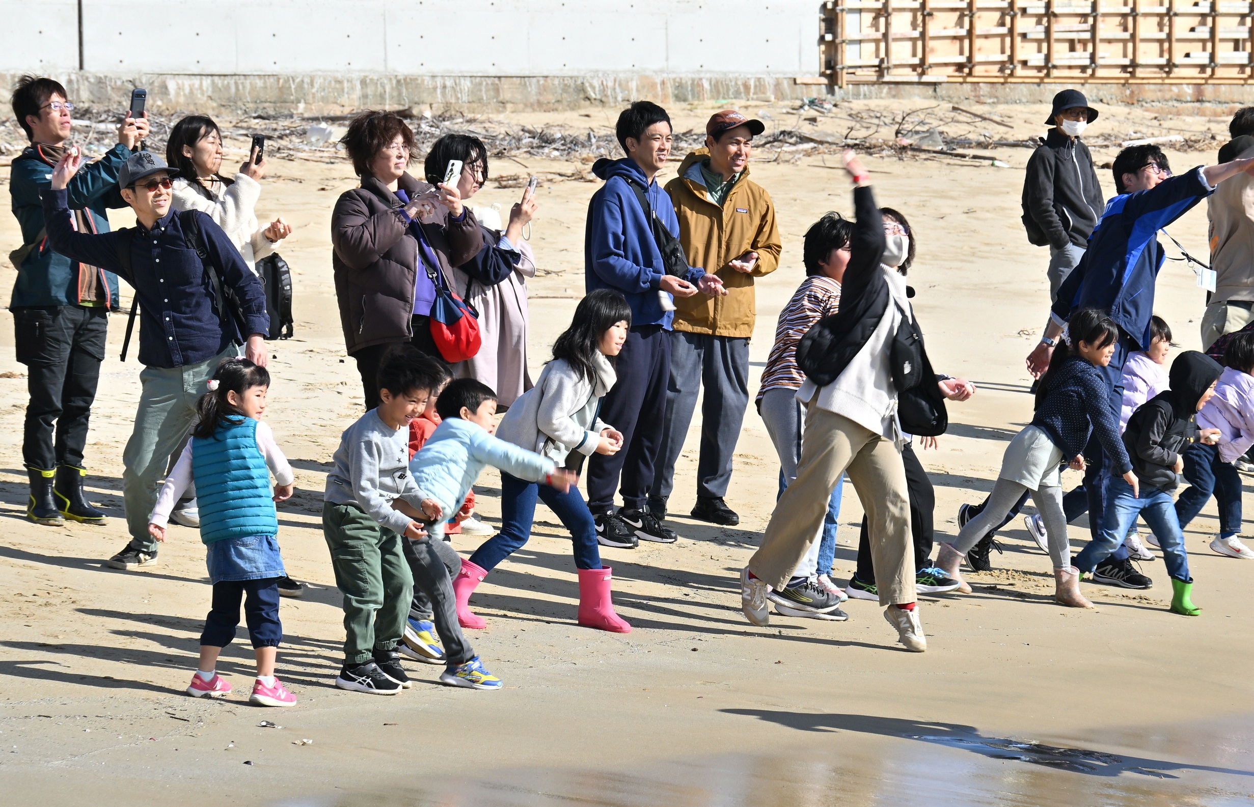 アマモ種子団子を海へ投げ入れる親子