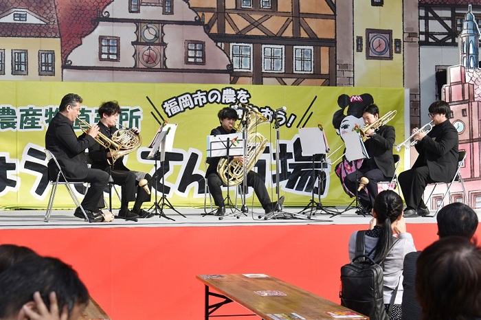 イベントのステージで、西区フィルハーモニーオーケストラが演奏をしている写真