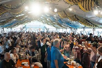 大きなテントの下でドイツのビールとフードを楽しんでいる人たち