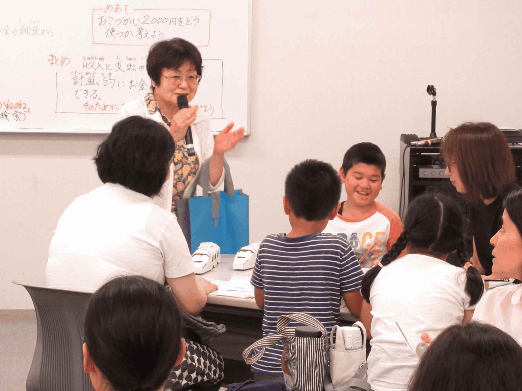 画像：講師がおこづかいゲームの説明をしている様子