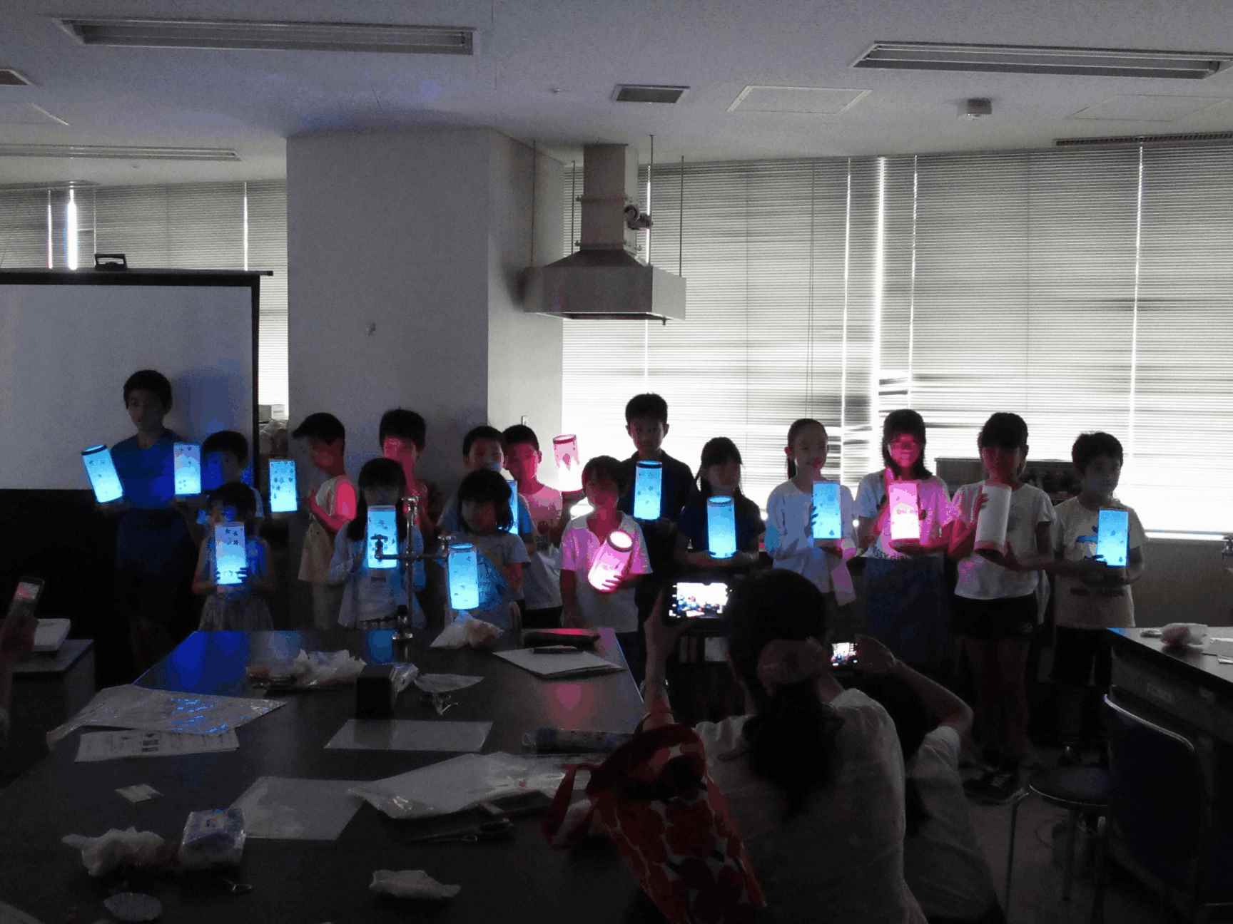 画像：完成したLEDランプを持って記念撮影している様子