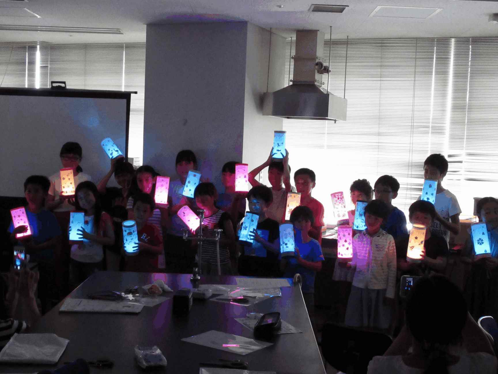 画像：完成したLEDランプを持って記念撮影している様子（午後の部）