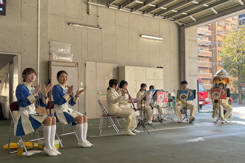 演奏を行う福岡市消防音楽隊と手拍子を行う福岡市消防カラーガード隊の写真