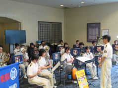 職場体験に来ていた警固中学校の生徒２名と共に演奏を行う福岡市消防音楽隊の写真