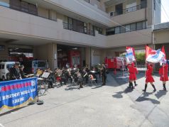 福岡市民防災センターで演奏と演技を行う福岡市消防音楽隊の写真