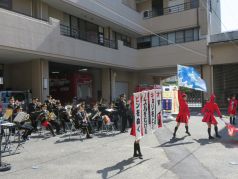 フラッグを炎と水に見立てて消火器の使い方を説明する福岡市消防カラーガード隊の写真