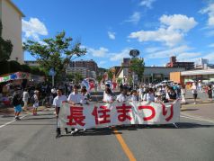 パレード隊の先頭で横断幕を持つ学生の写真