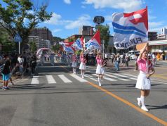 旗を振って演技を行うカラーガード隊の写真