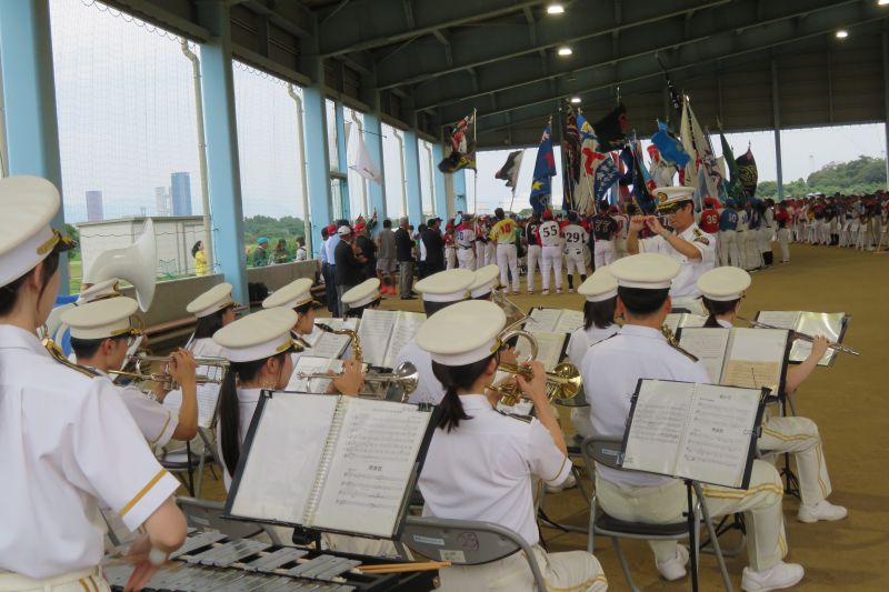 開会式で選手宣誓を行う選手たちと演奏を行う福岡市消防音楽隊の写真
