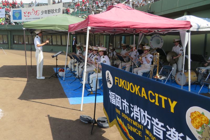 今津運動公園野球場で演奏する福岡市消防音楽隊の写真