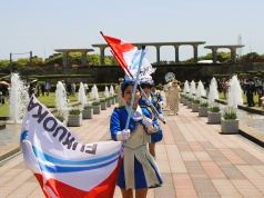 カラーガード隊を先頭にパレードをする消防音楽隊の写真