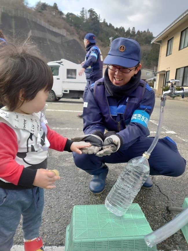 給水中に幼児と交流する福岡市水道局職員