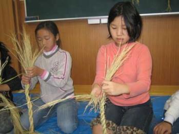 稲わらを上手に編んでいる児童