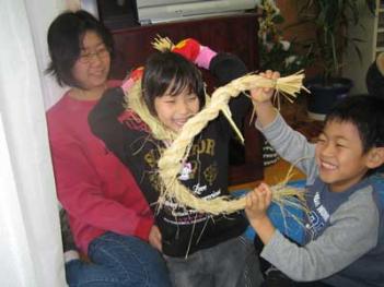 自分の編んだ縄をうれしそうに見せる児童