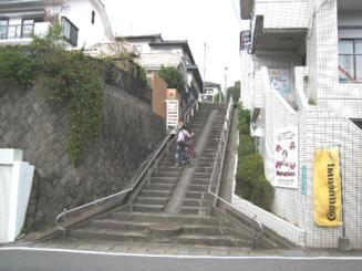 階段坂を自転車を押して歩いています