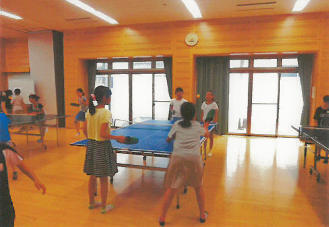 公民館で卓球をする子どもたちの写真