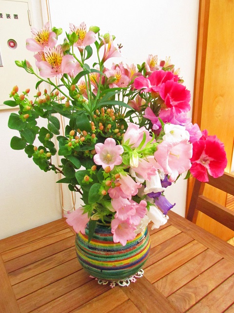 しかた公民館内にある薄い色から濃い色のピンクの花が咲いている花瓶の写真