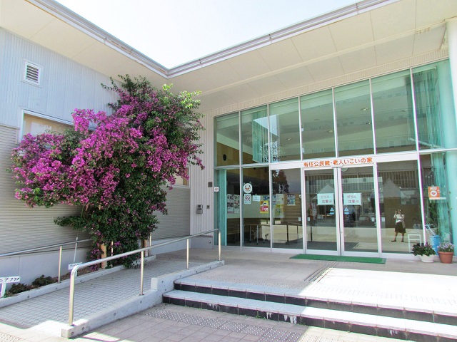 有住公民館とその入り口左側に植えられているブーゲンビリアの写真