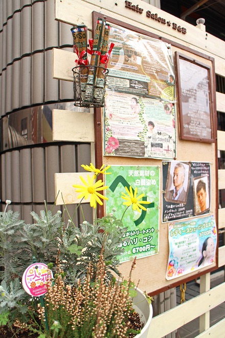 店舗前のおしゃれな看板と花の写真