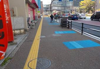 透水性舗装で整備され，自転車通行空間と色分けされた歩道の写真