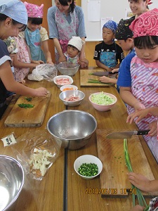 子どもたちが野菜を切っている写真