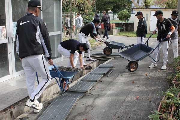 ソフトボールチームの団体が側溝清掃