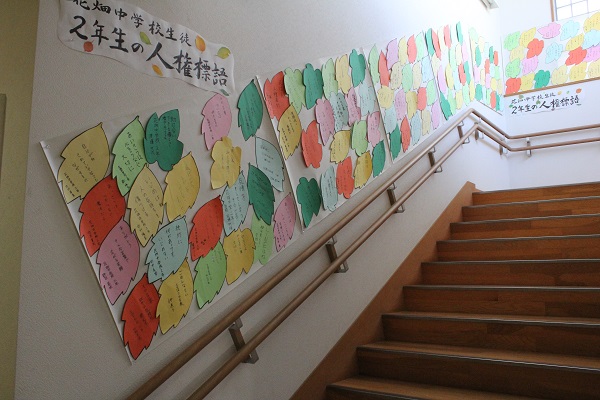 階段の壁に貼られたたくさんの人権標語。葉っぱの形の紙に書かれています。