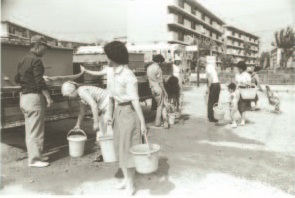 バケツに給水を受ける市民の写真