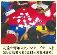 写真：令和元年8月に撮影した友達や青年スタッフとカードゲームを楽しむ若者たちの様子