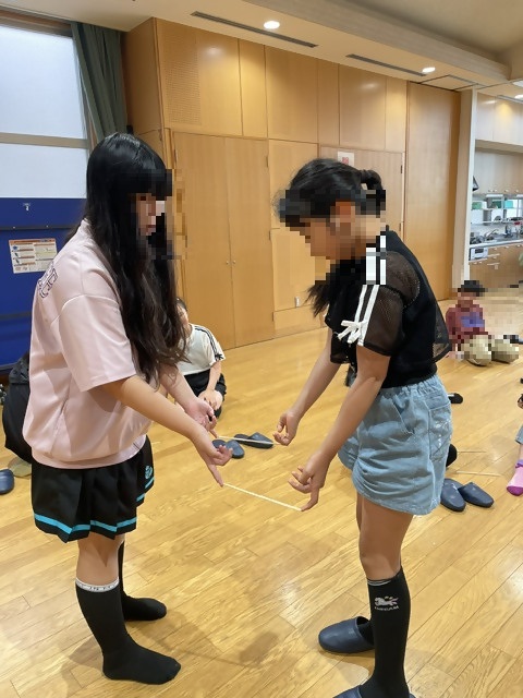 割りばしが落ちないよう向き合って一本指で支えて立つ