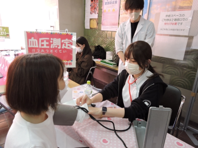 参加者が学生の血圧測定を受けている写真