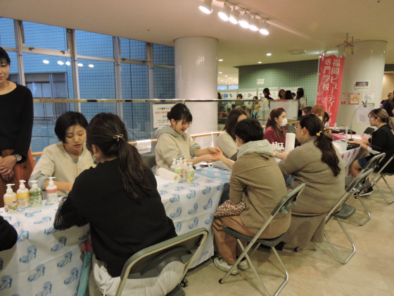 参加者がハンドマッサージを受けている写真