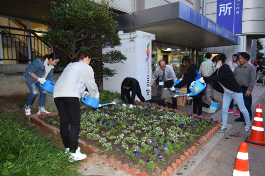 専門学生が植え替え後に水やりをしている写真