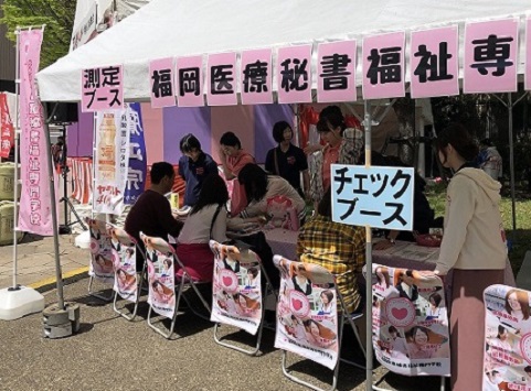 テントの下で参加者が健康チェックを受けている写真