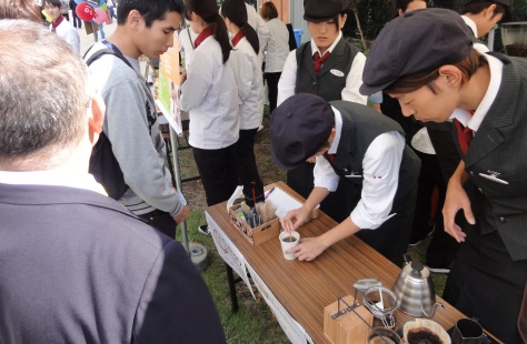 専門学生がカフェブースでコーヒーを入れている写真