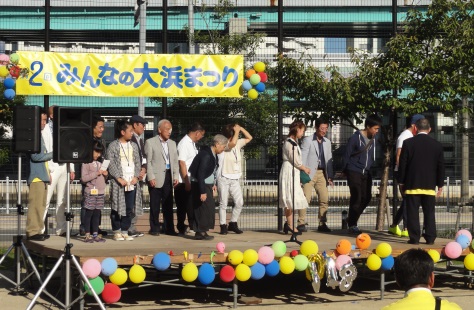 ステージで関係者が並んでいる写真