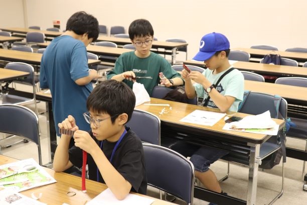 博多織キーホルダーを作成しているようす