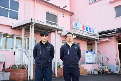 受賞施設の前に立つ 製造本部 業務課長代理 渡邉晃司さんと製造本部 部長 森山将介さん