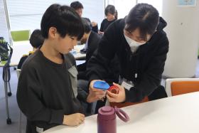 大学生スタッフが子どもと空気砲を制作する様子