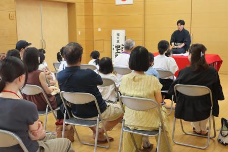 落語を披露する学生に聞き入る参加者